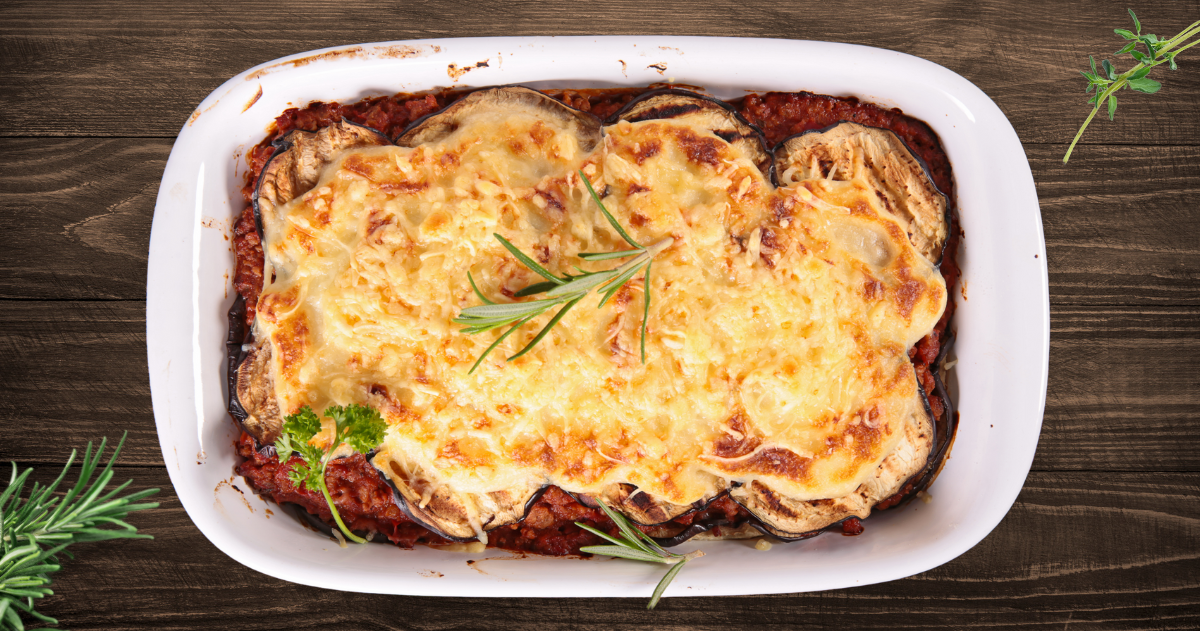 Musaka od pečenih paprika sa mlevenim mesom i pavlakom, servirana u vatrostalnoj posudi.